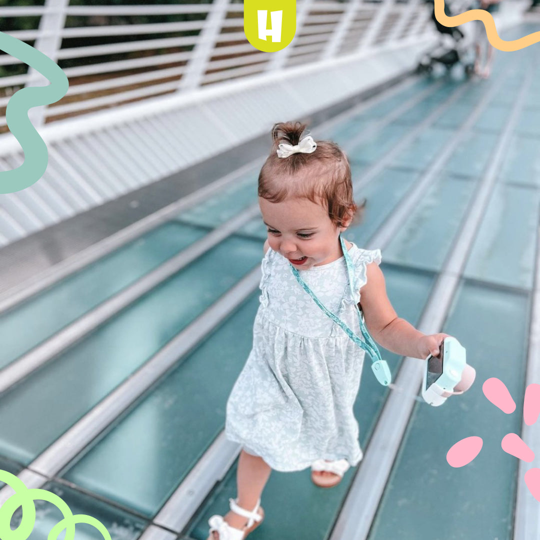 Petite fille marchant avec une caméra enfant et prenant des photos